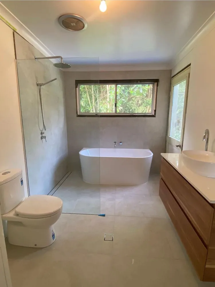 Completed bathroom renovation with freestanding bath, walk-in shower and timber vanity