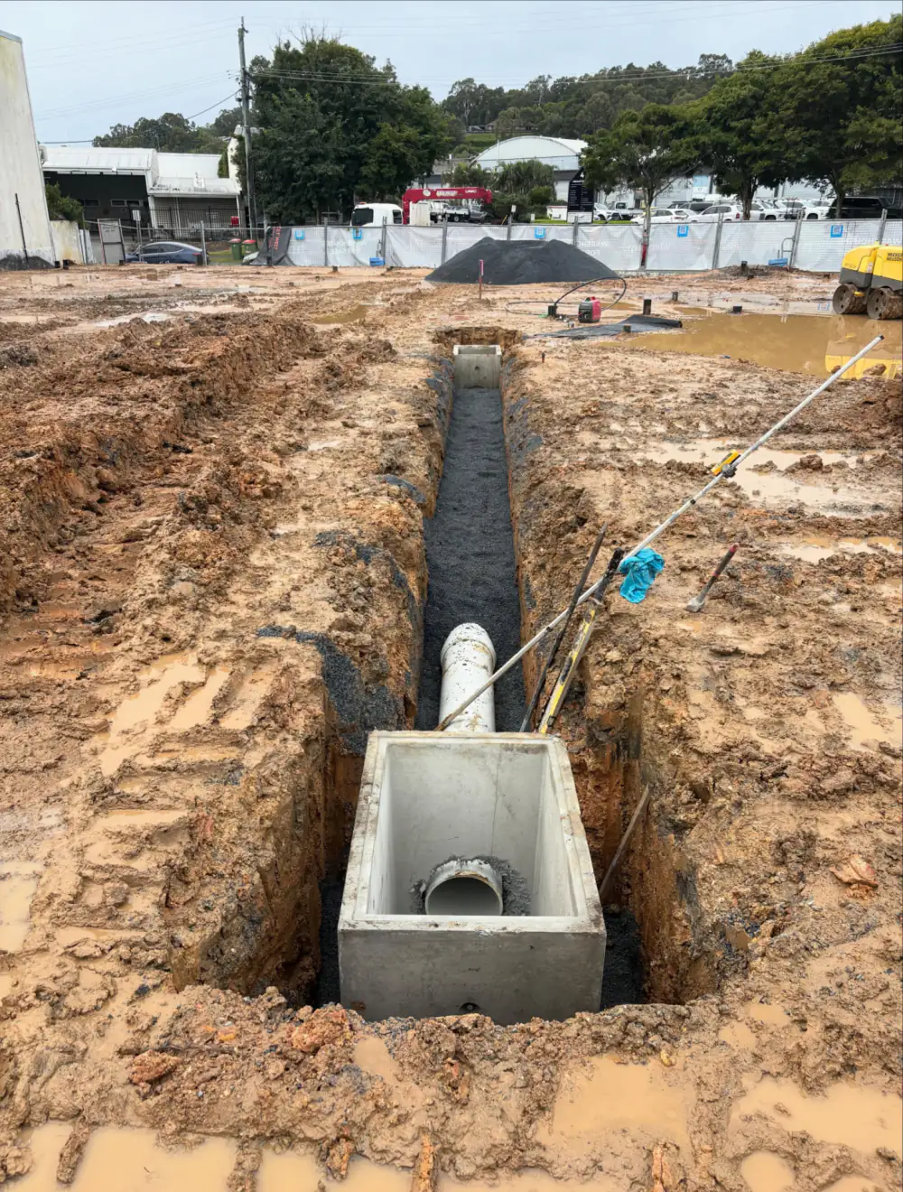 New concrete stormwater pit and 300mm PVC pipe laid in a gravel-bedded trench on the Burleigh warehouse site