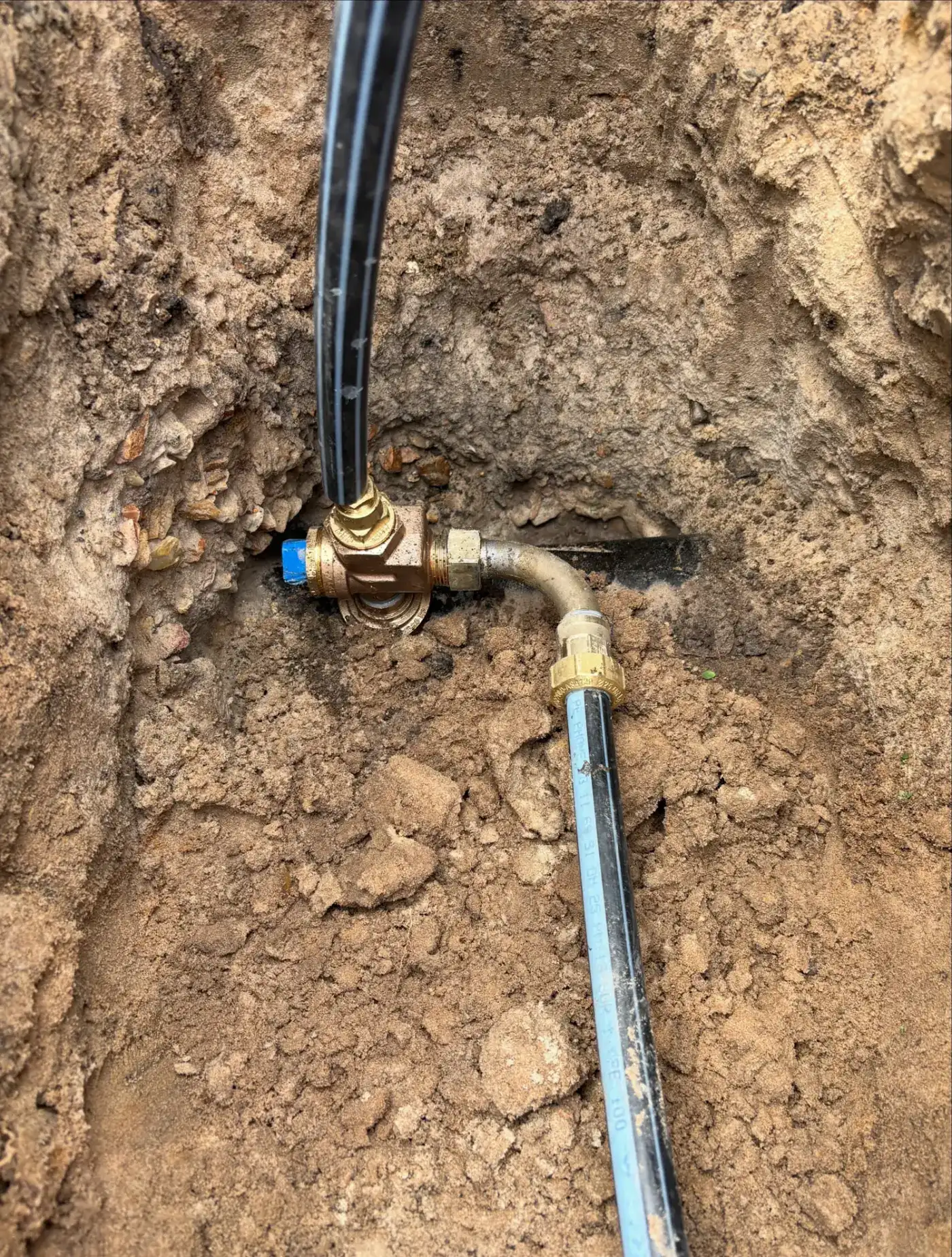 New 20mm water meter connection with brass ball valve and poly water service pipe in an open trench at Palm Beach