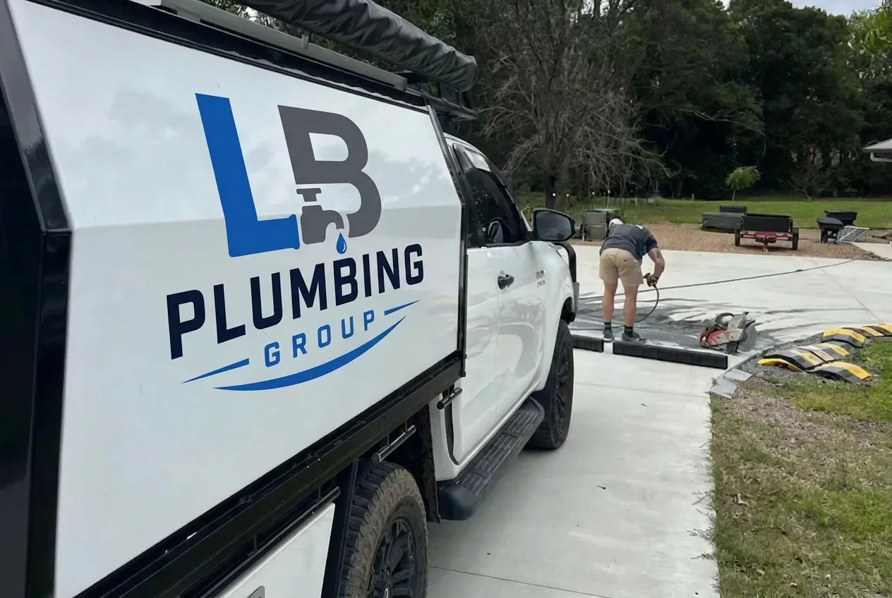 LB Plumbing Group work ute on a Gold Coast job site while a plumber cuts into a concrete driveway