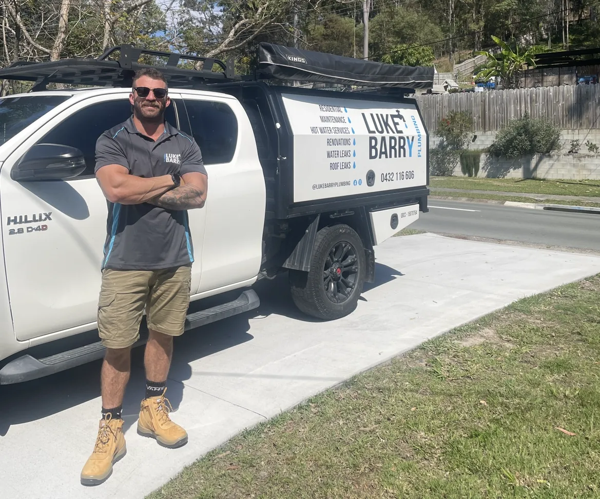 LB Plumbing Group plumber standing beside the signed work ute on the Gold Coast